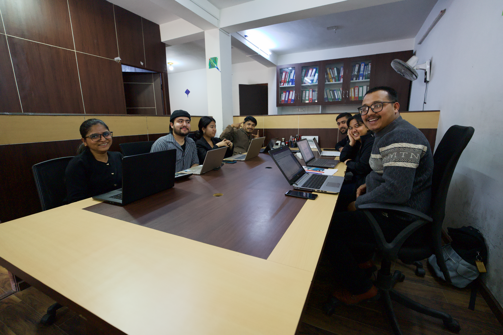 The A. Adhikari & Associates team working at laptops around the office table in Kupondole